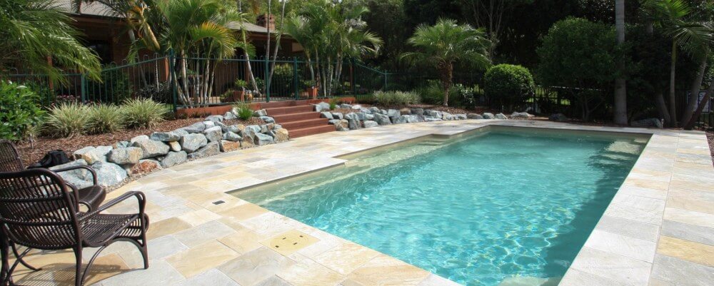 Natural pool design with stones and plants used in pool landscaping